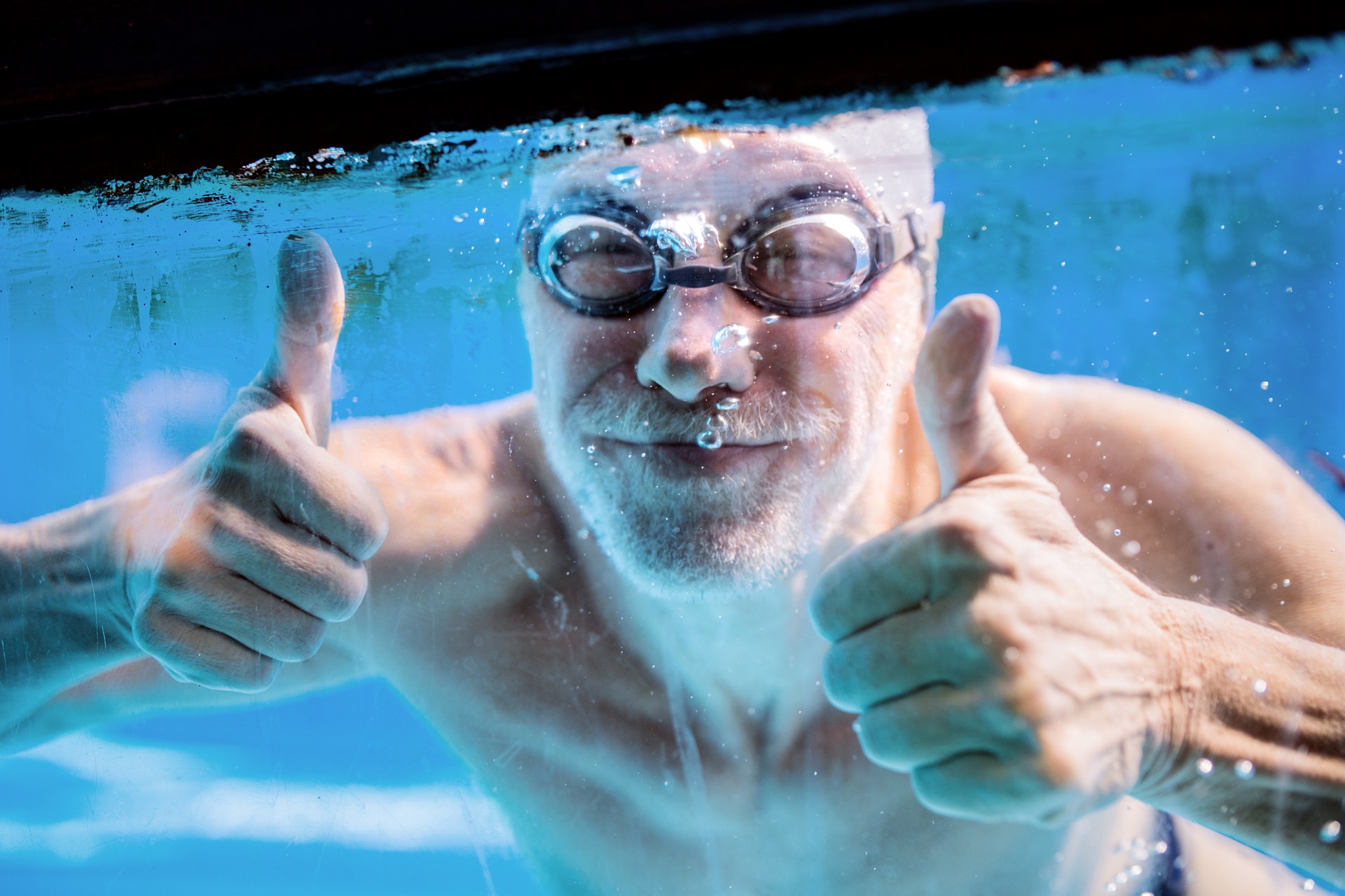 Lachender Schwimmer unter Wasser | Pools kaufen